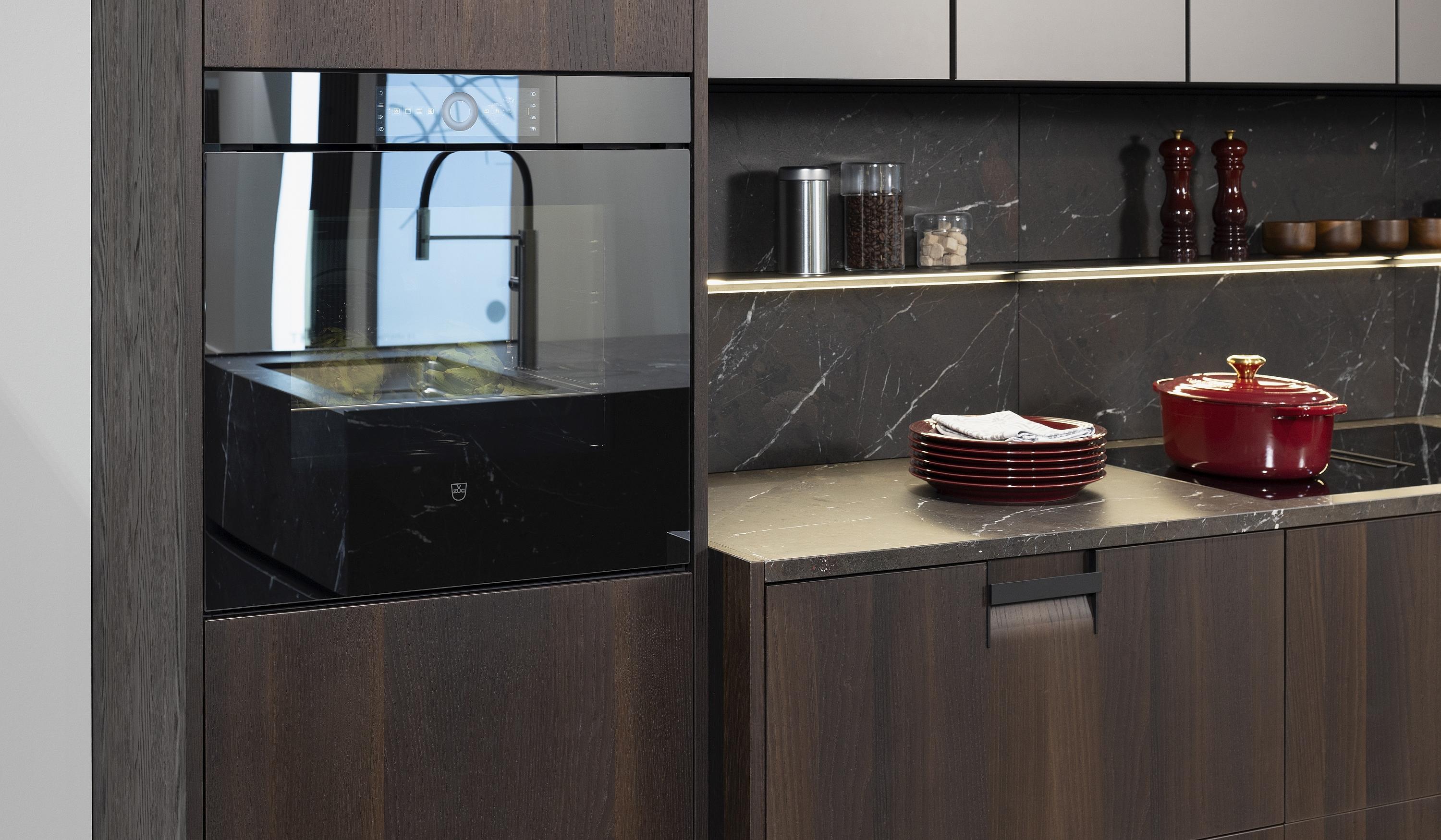 Einbauofen von V-ZUG mit Spiegelglas-Gerätefront in einer dunkelbraunen LEICHT Küche